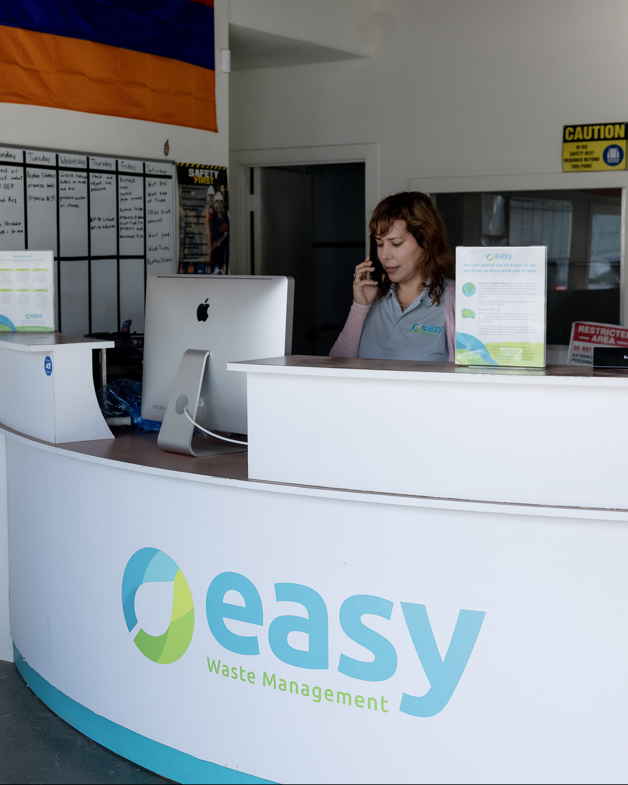 Receptionist at Easy Waste Management company desk speaking on the phone