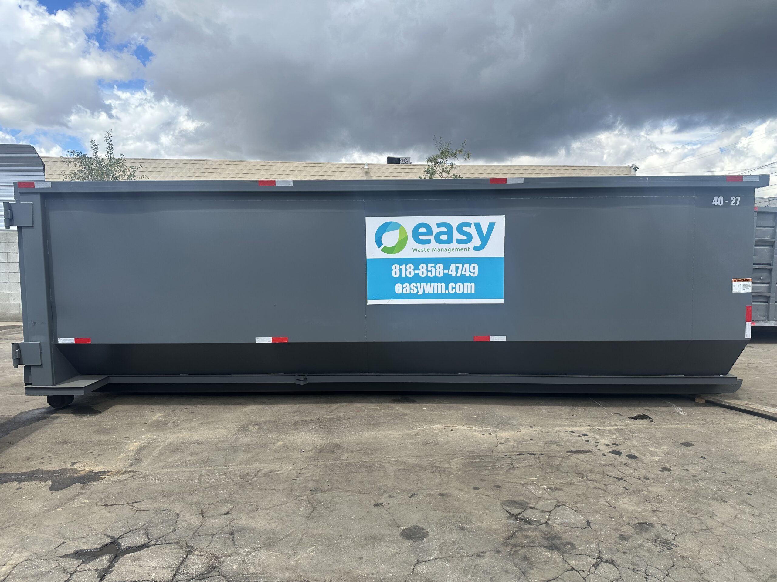 Gray dumpster with the logo and contact information